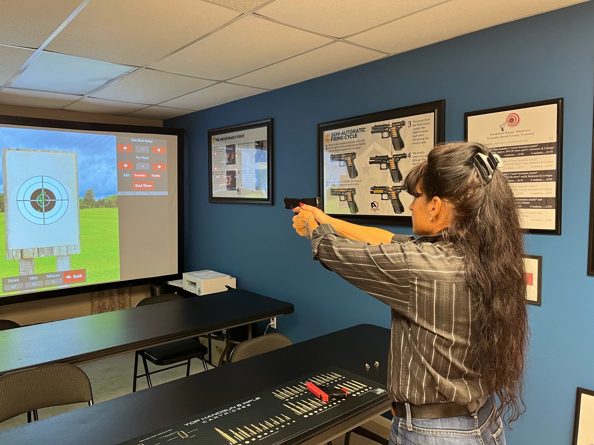Person aiming handgun at indoor shooting range
